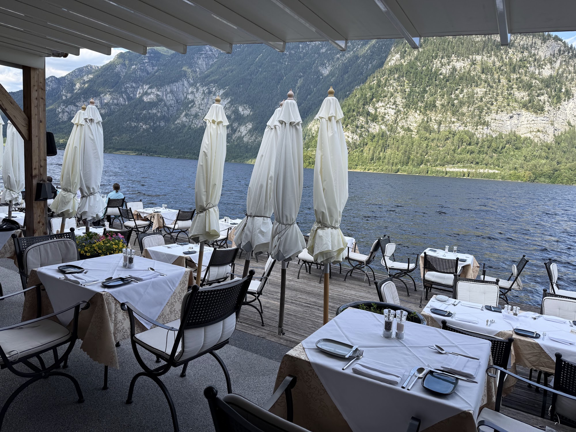 Set dining tables across the broad lakeside terrace