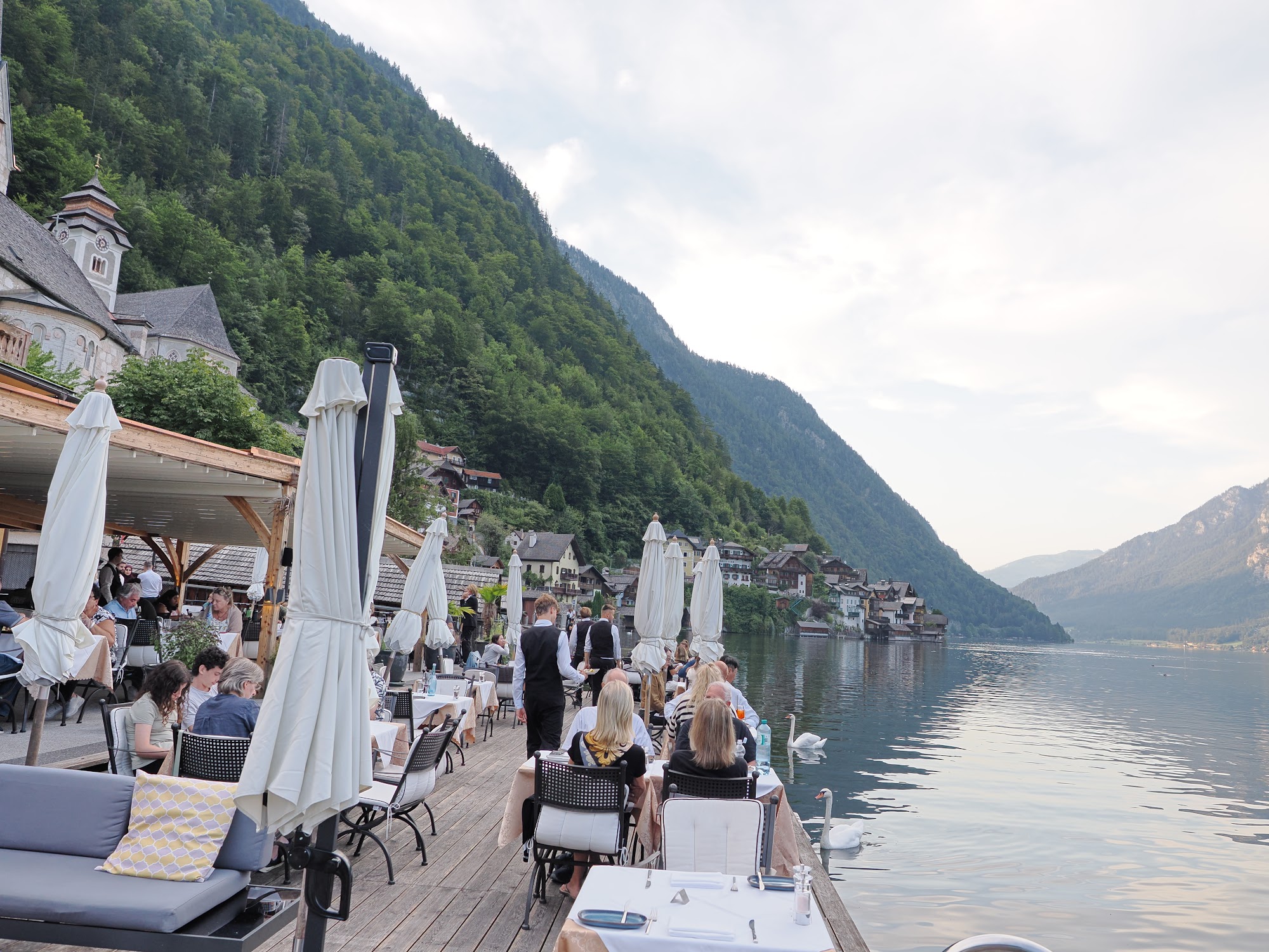 Guests dining on the terrace beside the lake